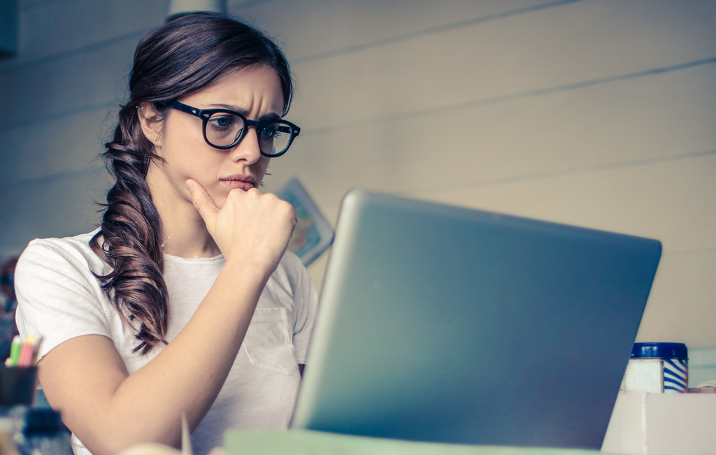 Woman looking frustrated at her laptop: Train with Contented writing courses and earn more income from writing in this Covid-19 crisis